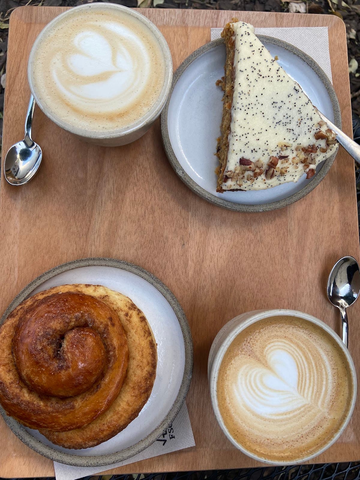 Cinnamon roll, carrot cake au pavot et deux flat whites vus du dessus