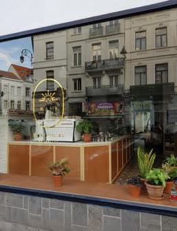 La vitrine de Kami chaussée de Waterloo, logo doré sur la vitre et plantes en pots de terre cuite